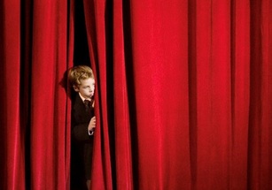 Nervous Boy Entering Stage from Behind Curtain